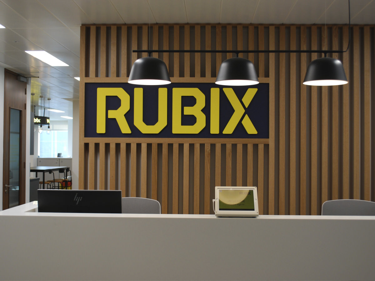 rubix-index - Workplace design & build - office reception with client company signage and timber clad back wall
